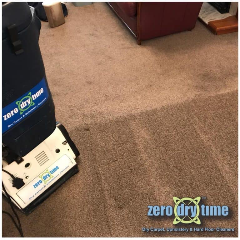 A carpet cleaning machine lifting stains from a brown carpet in a living room