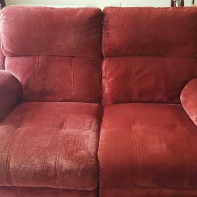 A red recliner chair in a living room.