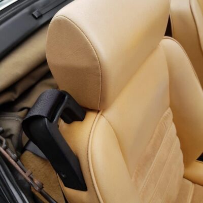 The interior of a tan sports car with leather seats.